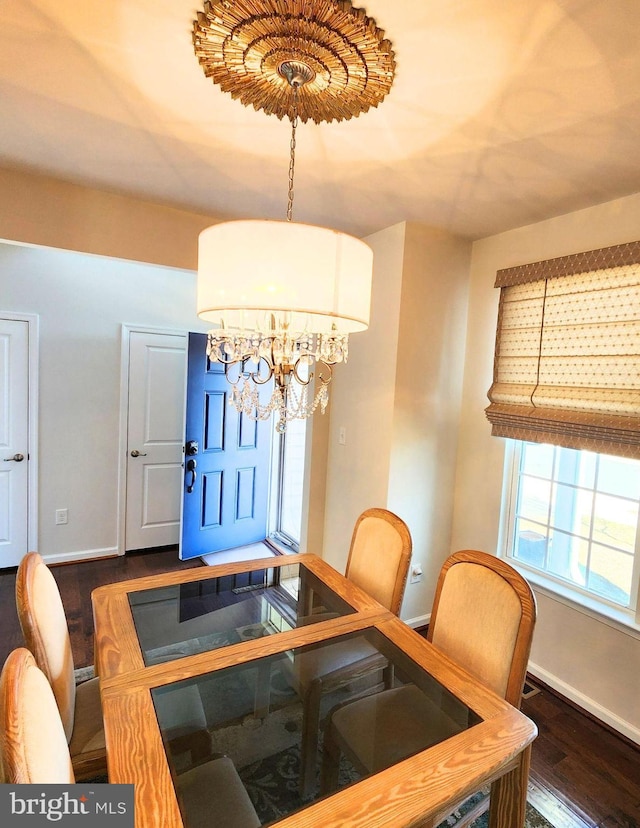 dining space featuring dark hardwood / wood-style flooring and a chandelier