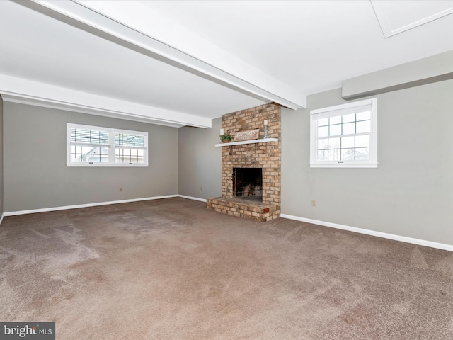 unfurnished living room featuring a fireplace, beamed ceiling, carpet flooring, and a healthy amount of sunlight