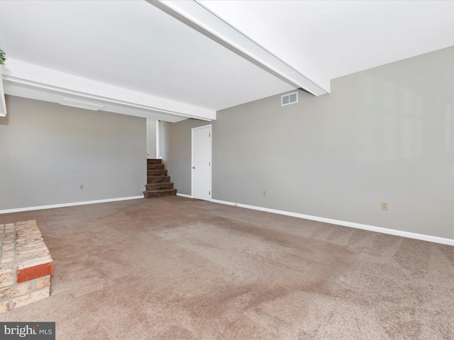 unfurnished living room with carpet flooring and beam ceiling