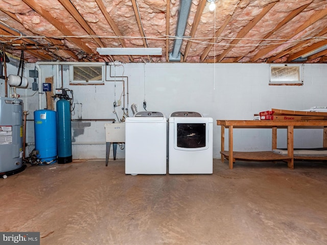 basement with sink, electric water heater, and washing machine and clothes dryer