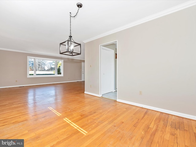 unfurnished dining area with hardwood / wood-style floors, an inviting chandelier, and ornamental molding