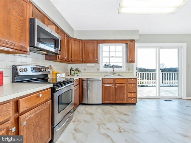 kitchen featuring decorative backsplash, sink, and stainless steel appliances