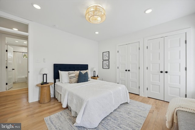 bedroom featuring two closets and light hardwood / wood-style floors