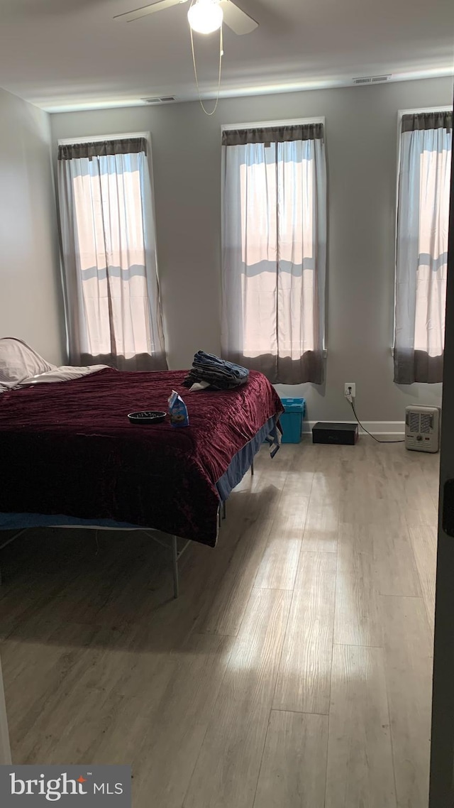 bedroom with ceiling fan and light wood-type flooring