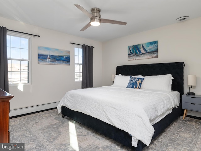 bedroom featuring a baseboard heating unit and ceiling fan