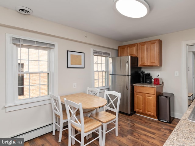 kitchen featuring a baseboard heating unit, dark wood-type flooring, and stainless steel fridge