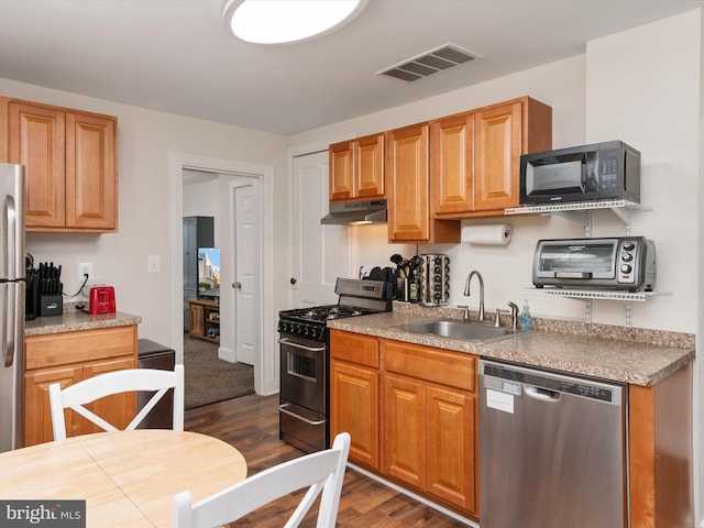 kitchen featuring stainless steel appliances, sink, and dark hardwood / wood-style floors