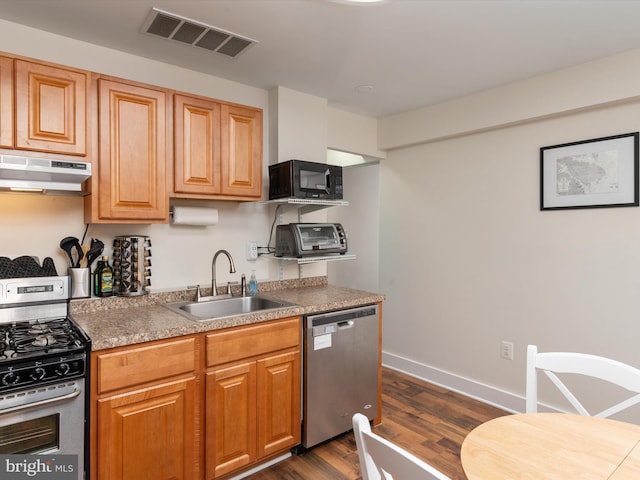 kitchen with dark wood-type flooring, stainless steel appliances, and sink