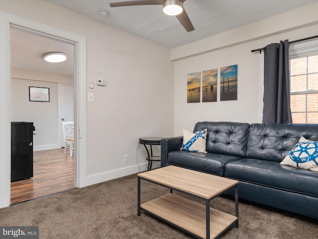 living room featuring ceiling fan, carpet, and a textured ceiling