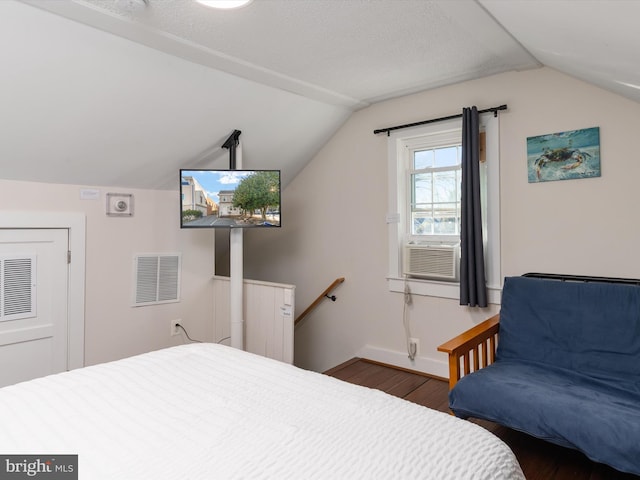 bedroom featuring dark wood-type flooring, lofted ceiling, a textured ceiling, and cooling unit