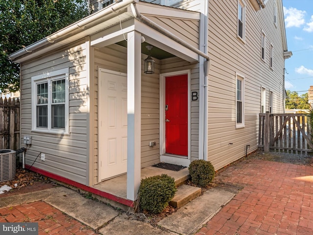 doorway to property with cooling unit and a patio area