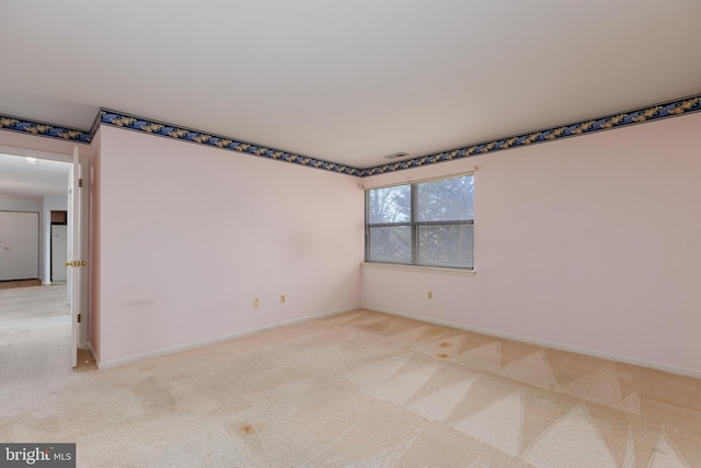 unfurnished room featuring light colored carpet