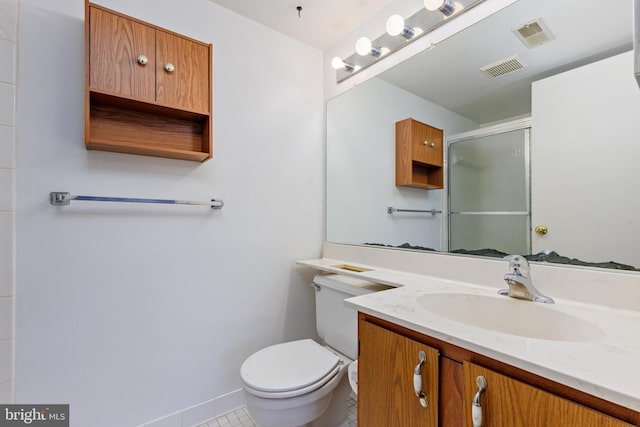 bathroom with vanity, tile patterned flooring, a shower with door, and toilet