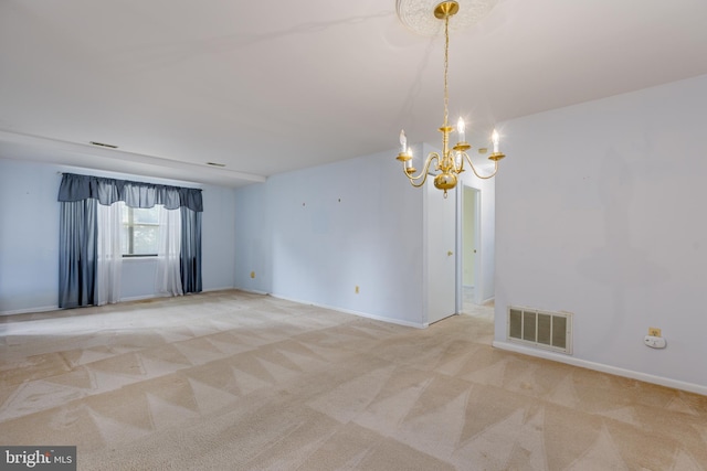 spare room with an inviting chandelier and carpet flooring