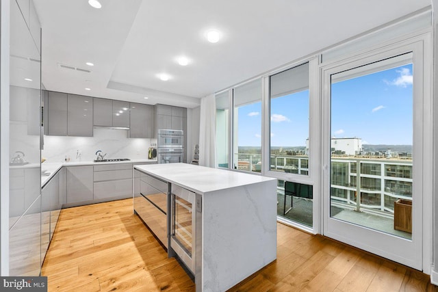 kitchen with plenty of natural light, gray cabinetry, gas cooktop, and light hardwood / wood-style floors