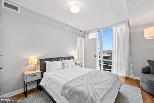 bedroom featuring hardwood / wood-style floors and a wall mounted air conditioner