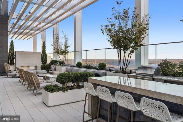 view of patio featuring area for grilling, a pergola, an outdoor kitchen, and exterior bar