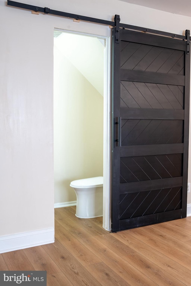 bathroom featuring toilet, baseboards, and wood finished floors