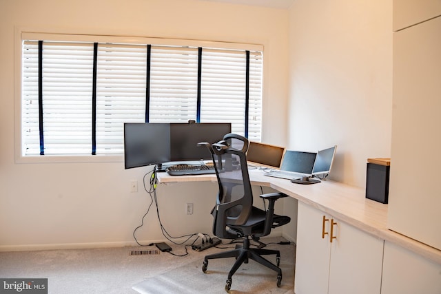 home office featuring light colored carpet, visible vents, and baseboards