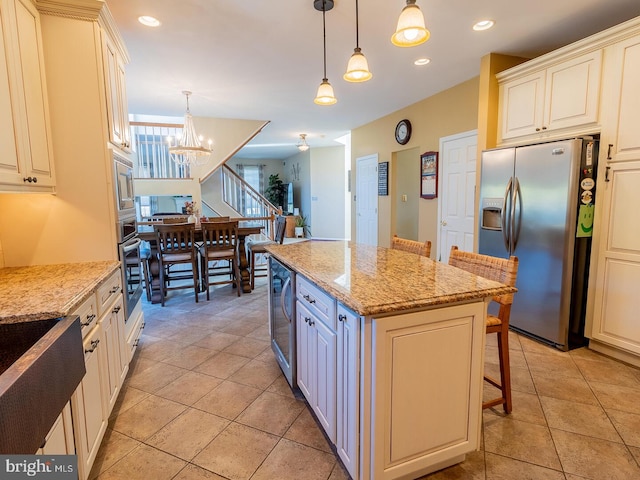 kitchen with stainless steel appliances, a kitchen island, a breakfast bar, and hanging light fixtures