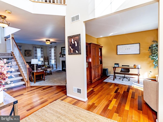 foyer featuring hardwood / wood-style floors, ceiling fan, and a high ceiling