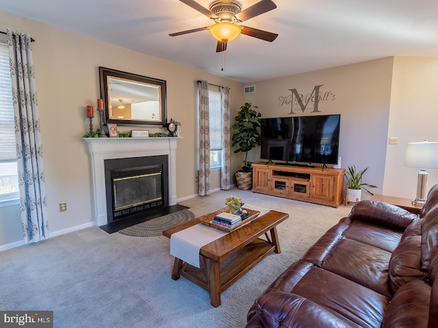 carpeted living room with ceiling fan