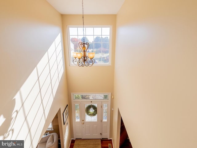 foyer entrance with a high ceiling and a notable chandelier