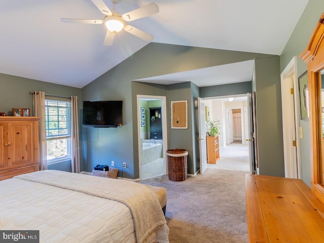 bedroom featuring vaulted ceiling, light colored carpet, ceiling fan, and ensuite bathroom