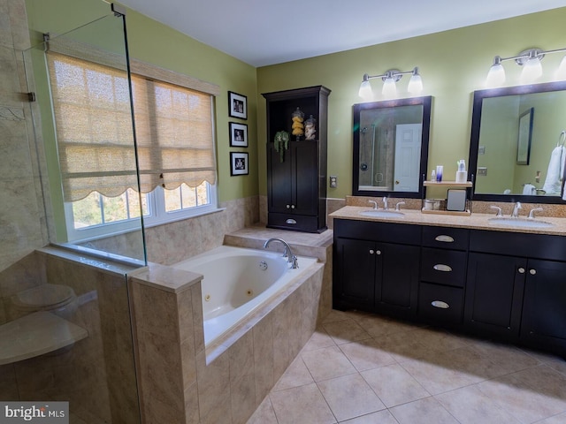 bathroom featuring vanity, tile patterned floors, and tiled bath