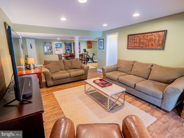 living room with ornate columns and light hardwood / wood-style floors