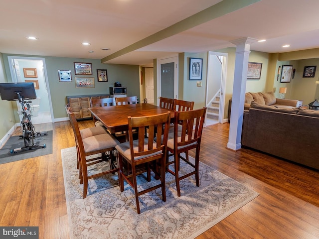 dining area featuring hardwood / wood-style floors and ornate columns