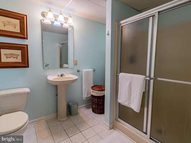 bathroom featuring tile patterned flooring, a shower with door, and toilet