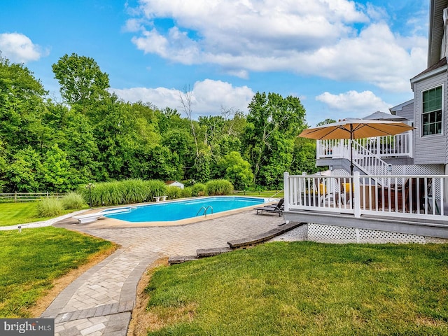 view of pool with a patio, a diving board, a yard, and a deck