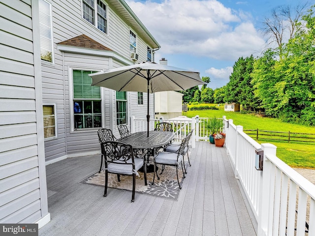 wooden terrace with a shed and a lawn