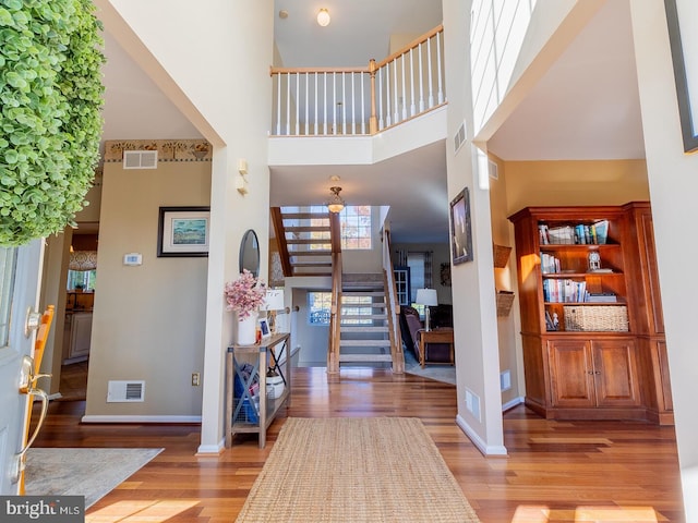 entrance foyer with a skylight, light hardwood / wood-style flooring, and a high ceiling