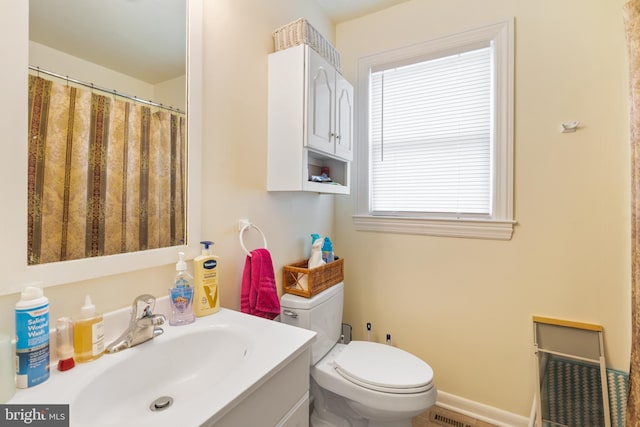 bathroom with toilet, a shower with shower curtain, vanity, and baseboards