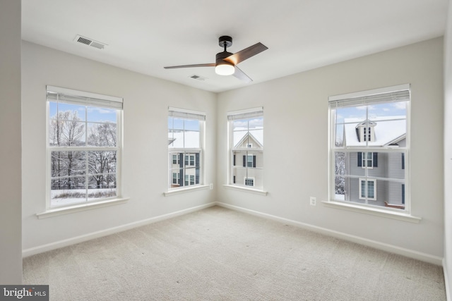 carpeted empty room with ceiling fan and a healthy amount of sunlight