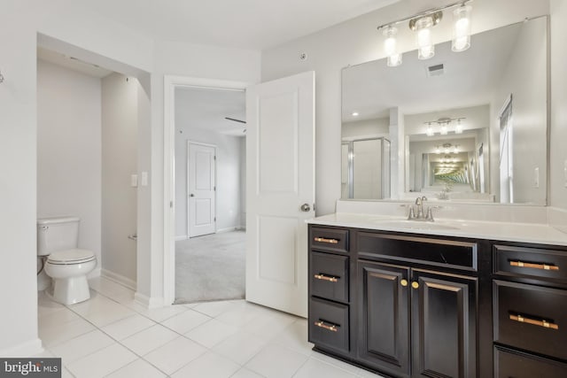 bathroom with tile patterned flooring, vanity, an enclosed shower, and toilet