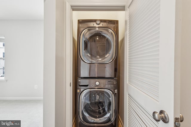 laundry room with stacked washer and dryer and carpet flooring