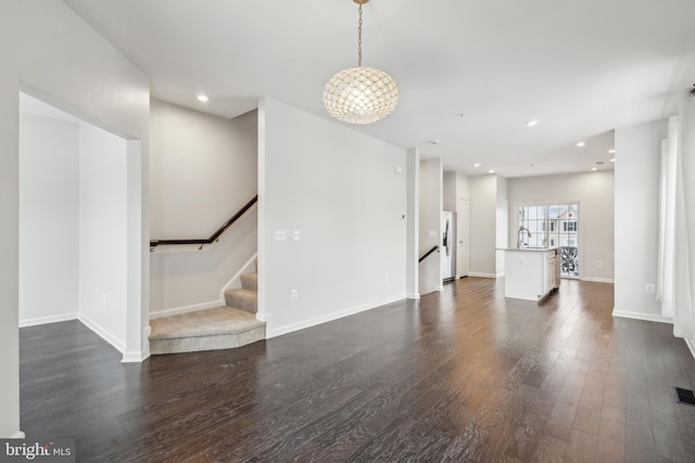 unfurnished living room with dark wood-type flooring and sink