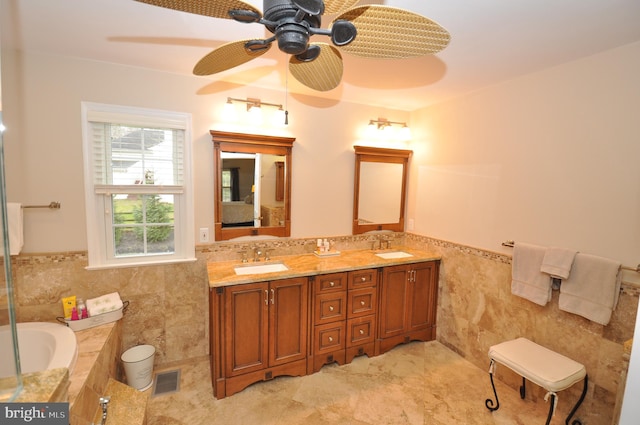 bathroom with vanity, tile walls, and tiled bath