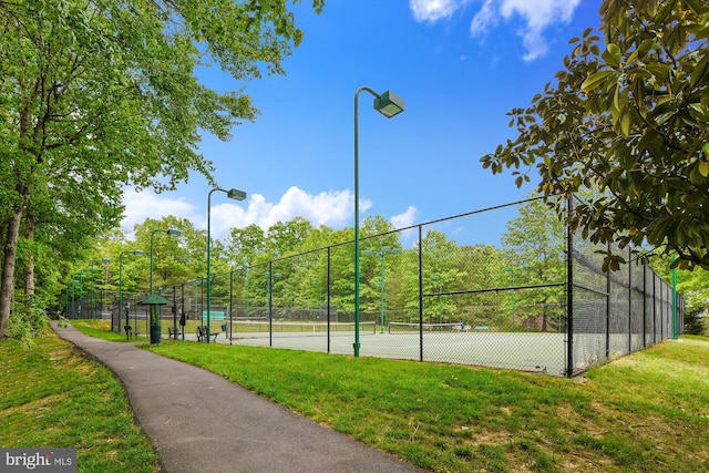 view of tennis court featuring a lawn