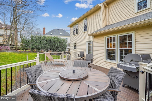 wooden deck featuring area for grilling and a lawn