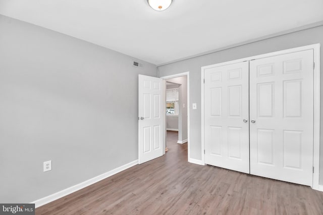 unfurnished bedroom featuring wood-type flooring and a closet