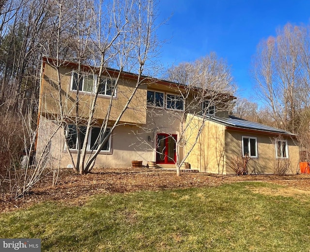 view of front of home with a front lawn and stucco siding