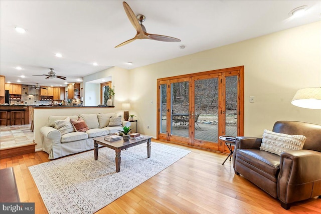 living room featuring recessed lighting, a ceiling fan, and light wood-style floors