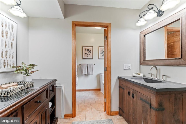 bathroom with toilet, baseboards, and vanity