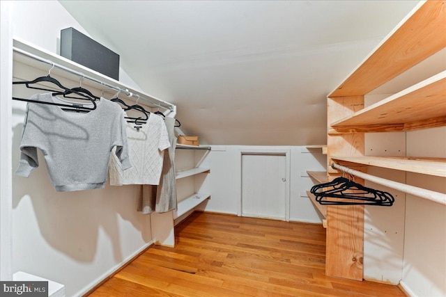 walk in closet with lofted ceiling and light wood-style flooring