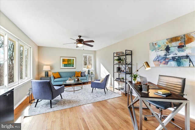 interior space with light wood-style floors, baseboards, and a ceiling fan