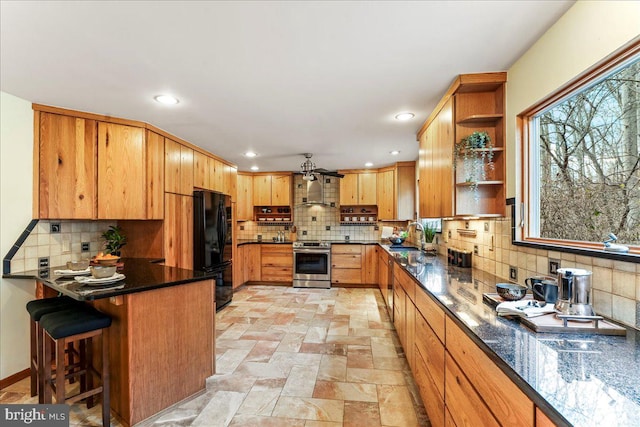 kitchen featuring freestanding refrigerator, a peninsula, stainless steel electric range, open shelves, and a sink